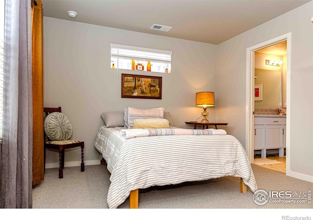 506 Bobcat Ct, Wiggins, CO 80654 - carpeted bedroom featuring baseboards and ensuite bathroom