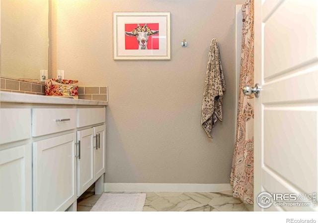 506 Bobcat Ct, Wiggins, CO 80654 - full bath featuring marble finish floors, baseboards, and vanity