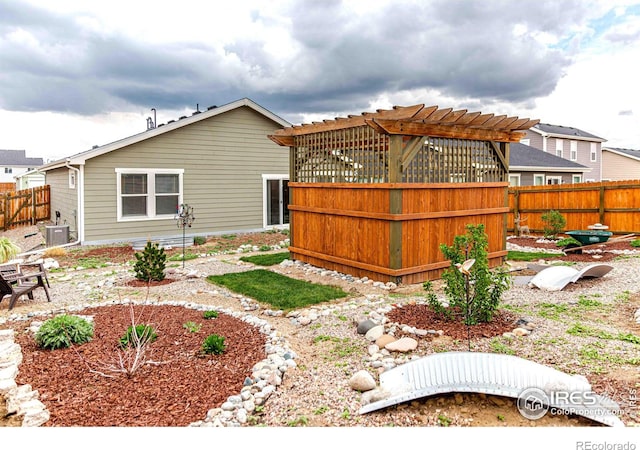 506 Bobcat Ct, Wiggins, CO 80654 - back of house with cooling unit, a fenced backyard, and a pergola