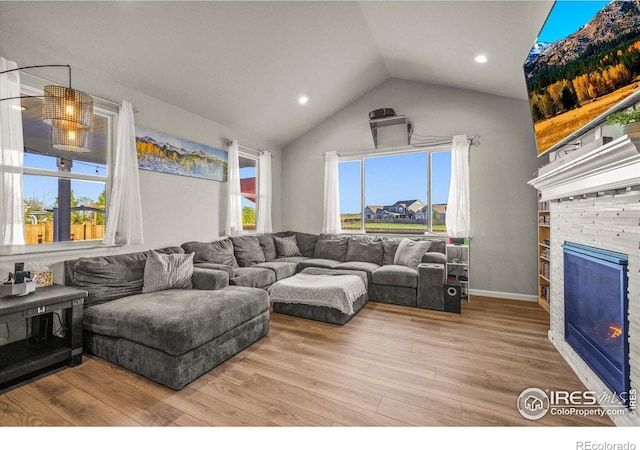 living room featuring lofted ceiling, wood finished floors, a fireplace, and recessed lighting