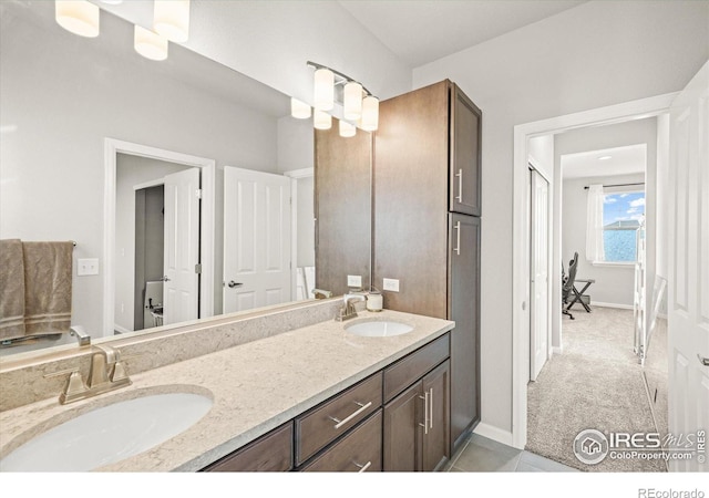 bathroom with double vanity and baseboards