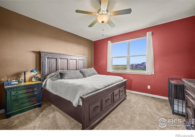 bedroom with light colored carpet, baseboards, and a ceiling fan