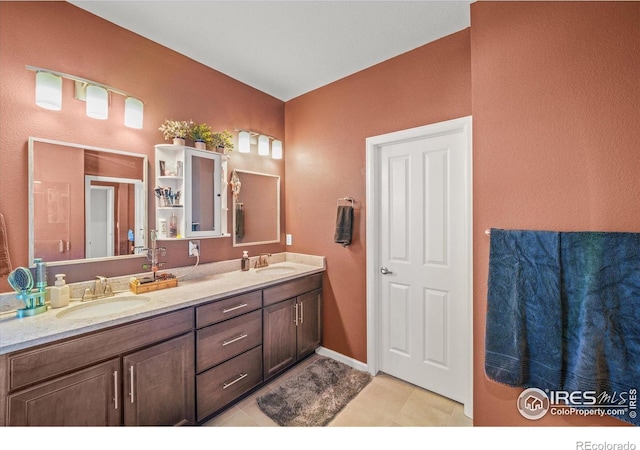 full bath featuring double vanity, tile patterned floors, and a textured wall