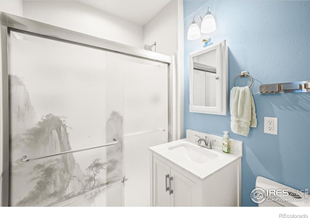 bathroom featuring vanity, toilet, and a shower