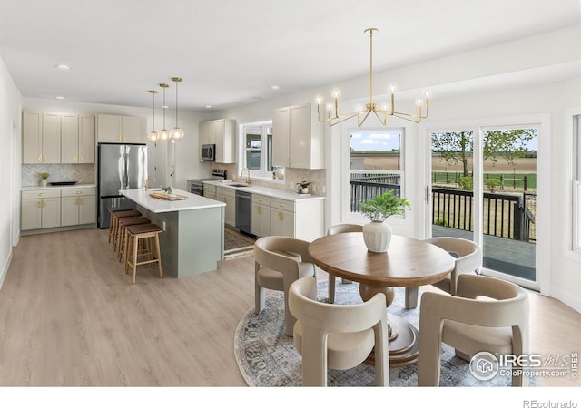dining area with a chandelier, light wood finished floors, and recessed lighting