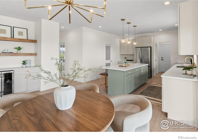 dining space with beverage cooler, light wood finished floors, a chandelier, recessed lighting, and baseboards