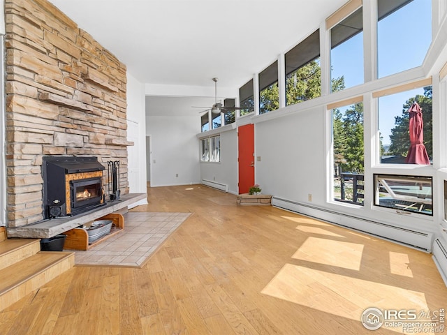 1411 Vail Ct, Estes Park, CO 80517 - unfurnished living room with ceiling fan, a fireplace, wood finished floors, a baseboard heating unit, and a high ceiling