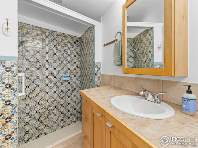 1411 Vail Ct, Estes Park, CO 80517 - bathroom with tiled shower, tile patterned floors, vanity, tasteful backsplash, and tile walls