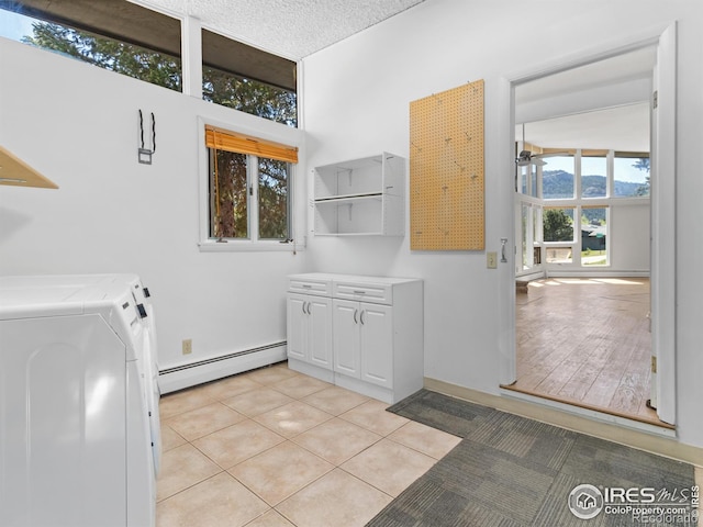 1411 Vail Ct, Estes Park, CO 80517 - laundry area with baseboard heating, washing machine and dryer, a ceiling fan, cabinet space, and light tile patterned flooring