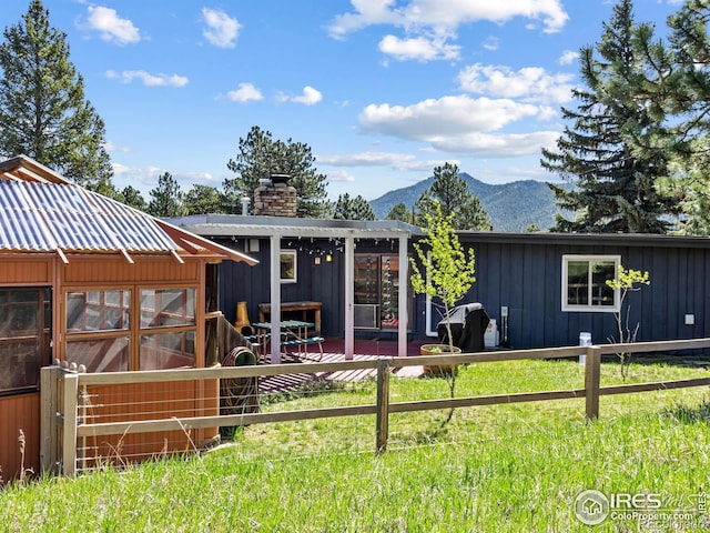 1411 Vail Ct, Estes Park, CO 80517 - back of house featuring board and batten siding, a mountain view, and a chimney