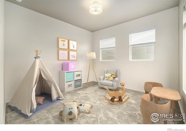 recreation room with baseboards and plenty of natural light