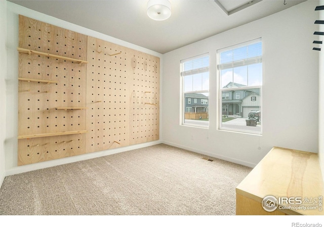 carpeted empty room with visible vents and baseboards