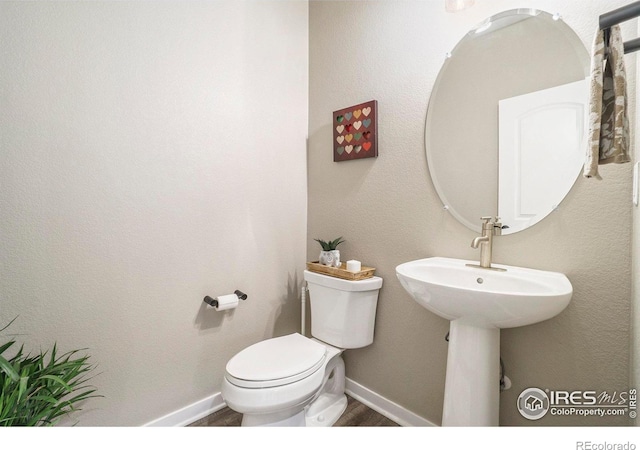 half bath with toilet and wood finished floors