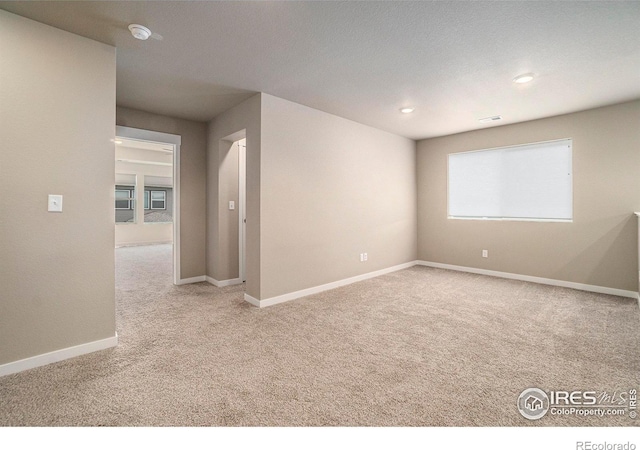 spare room with carpet floors, baseboards, and recessed lighting