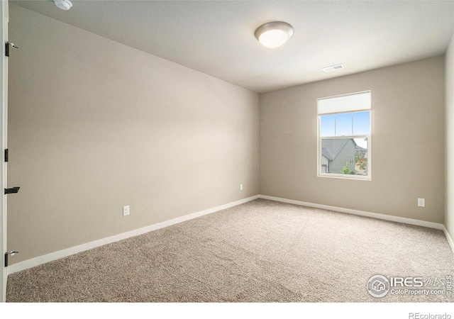 carpeted spare room with baseboards and visible vents