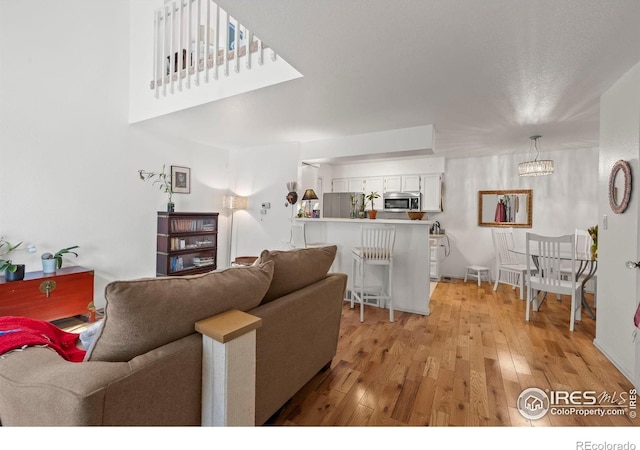 5086 Buckingham Rd, Boulder, CO 80301 - living room featuring light wood-style flooring and a chandelier