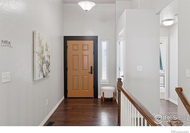 9137 Harlequin Cir, Frederick, CO 80504 - foyer entrance with dark wood-style floors, a high ceiling, and baseboards