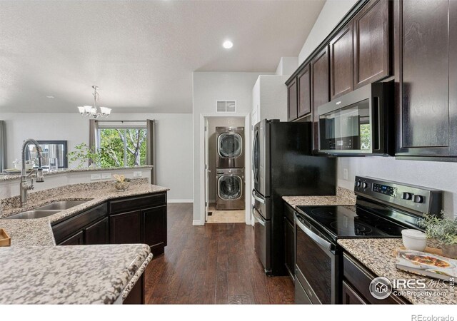 9137 Harlequin Cir, Frederick, CO 80504 - kitchen with appliances with stainless steel finishes, a sink, stacked washer / dryer, a chandelier, and dark brown cabinetry