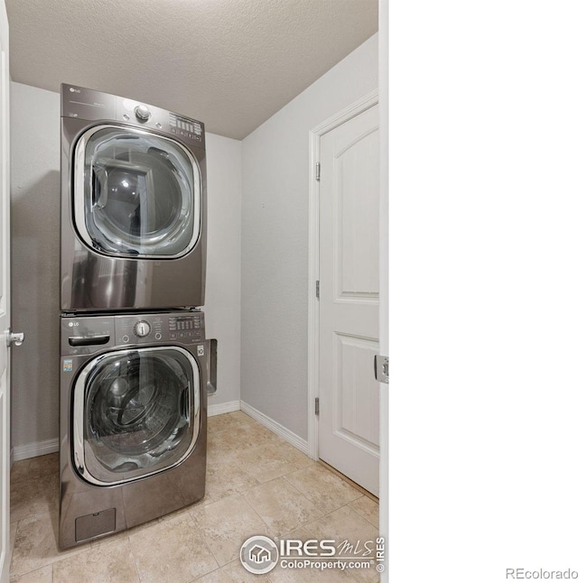 9137 Harlequin Cir, Frederick, CO 80504 - laundry area with stacked washer / drying machine, baseboards, and a textured ceiling