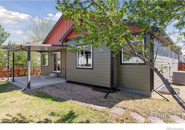 9137 Harlequin Cir, Frederick, CO 80504 - rear view of house featuring board and batten siding, a patio area, central AC unit, and fence