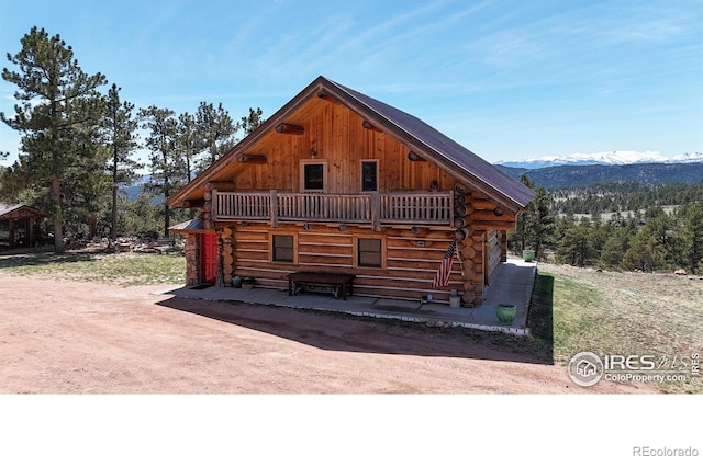 view of side of home featuring log siding and a mountain view