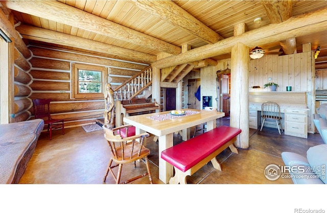 dining space with wood ceiling, concrete flooring, stairs, beam ceiling, and rustic walls