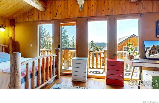 bedroom featuring hardwood / wood-style floors, multiple windows, wood walls, and wood ceiling
