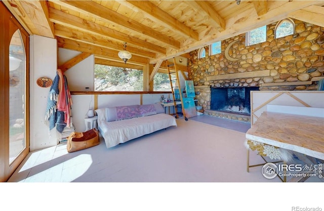 living room with wood ceiling, beam ceiling, and a stone fireplace
