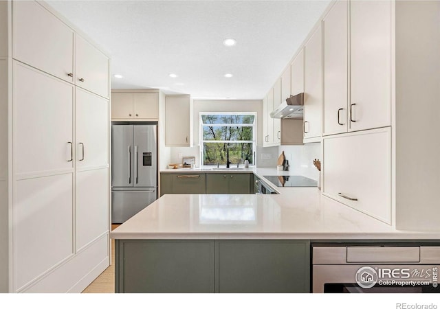 536 W Sycamore Cir, Louisville, CO 80027 - kitchen with high end refrigerator, under cabinet range hood, a sink, a peninsula, and recessed lighting