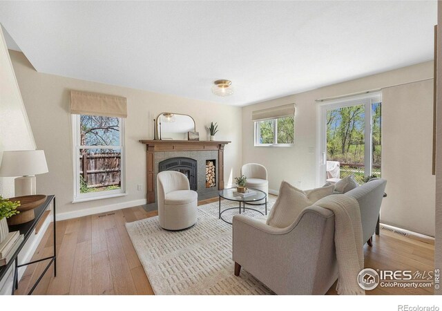 536 W Sycamore Cir, Louisville, CO 80027 - living area featuring a tiled fireplace, wood-type flooring, and baseboards