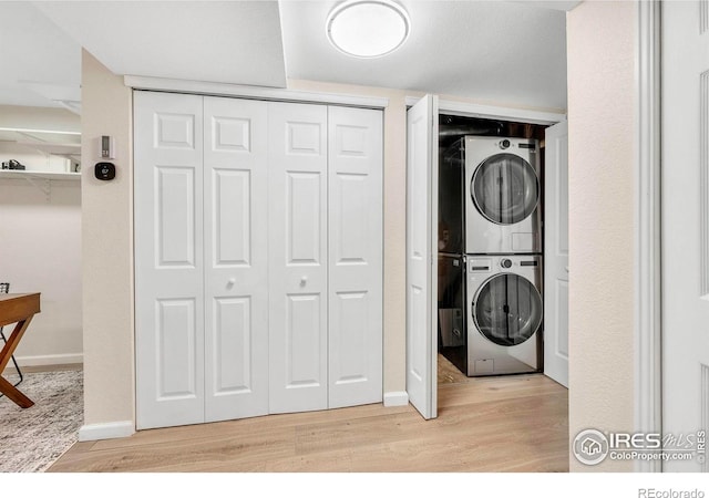 536 W Sycamore Cir, Louisville, CO 80027 - washroom featuring stacked washing machine and dryer, light wood-style flooring, and baseboards