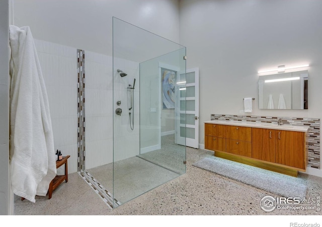 9360 Gold Mine Rd, Loveland, CO 80538 - bathroom featuring speckle patterned floor, baseboards, walk in shower, and vanity