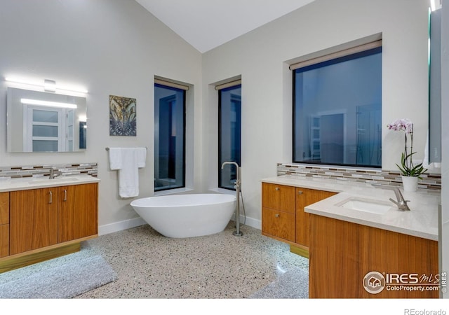9360 Gold Mine Rd, Loveland, CO 80538 - full bathroom featuring baseboards, backsplash, speckle patterned floor, two vanities, and a freestanding bath