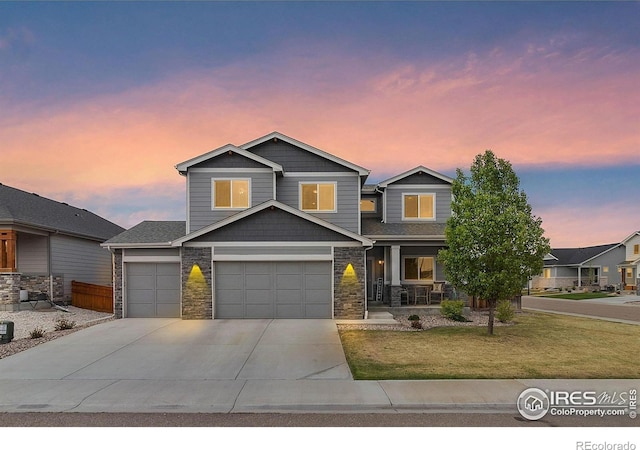 craftsman house with covered porch, a yard, concrete driveway, stone siding, and a garage