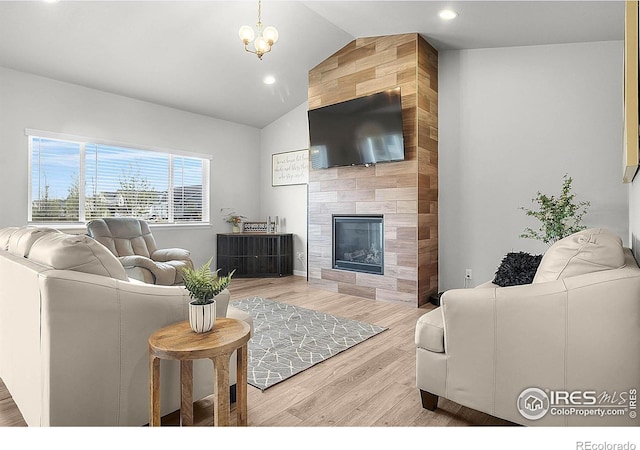 living room with lofted ceiling, wood finished floors, recessed lighting, and a fireplace