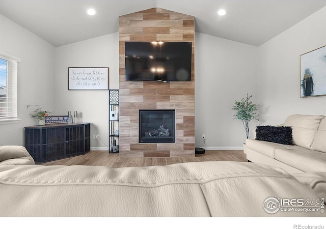 living room with lofted ceiling, wood finished floors, baseboards, a fireplace, and recessed lighting