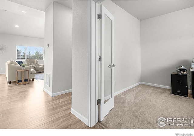 hallway with wood finished floors, baseboards, and recessed lighting