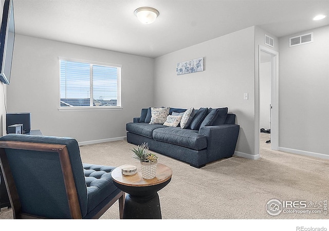 carpeted living area with baseboards and recessed lighting