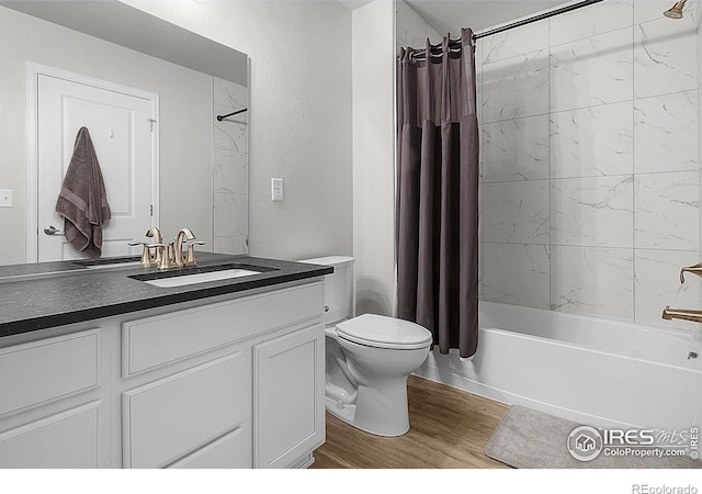 full bathroom featuring wood finished floors, toilet, shower / bath combination with curtain, and vanity