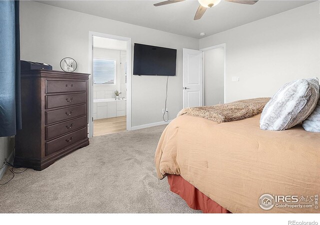 bedroom featuring carpet floors, baseboards, ensuite bathroom, and a ceiling fan