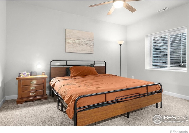 bedroom with light colored carpet, baseboards, and a ceiling fan