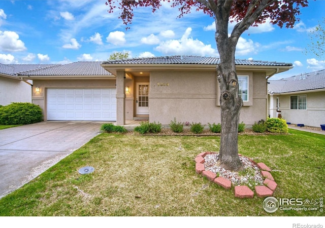 5308 W 11th St, Greeley, CO 80634 - view of front of house featuring a tiled roof, a front yard, a garage, driveway, and stucco siding