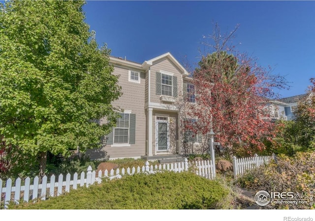 traditional-style home with a fenced front yard