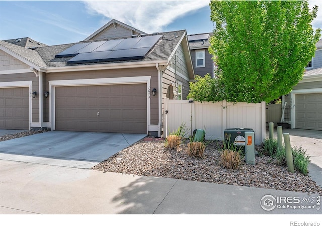 1675 Saratoga Dr, Lafayette, CO 80026 - view of front of house featuring concrete driveway, solar panels, a garage, a shingled roof, and a gate