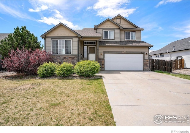 7235 Andover St, Wellington, CO 80549 - split level home with concrete driveway, a garage, and stone siding