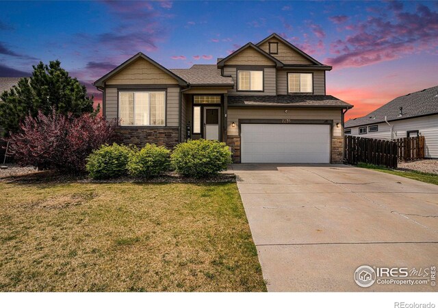7235 Andover St, Wellington, CO 80549 - tri-level home featuring stone siding, an attached garage, and concrete driveway