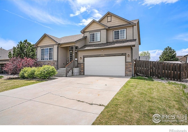 7235 Andover St, Wellington, CO 80549 - view of front facade featuring an attached garage, driveway, and stone siding