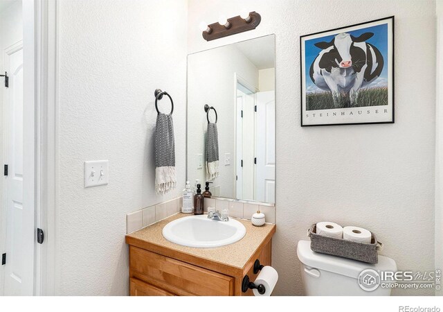 7235 Andover St, Wellington, CO 80549 - bathroom with vanity, toilet, and a textured wall
