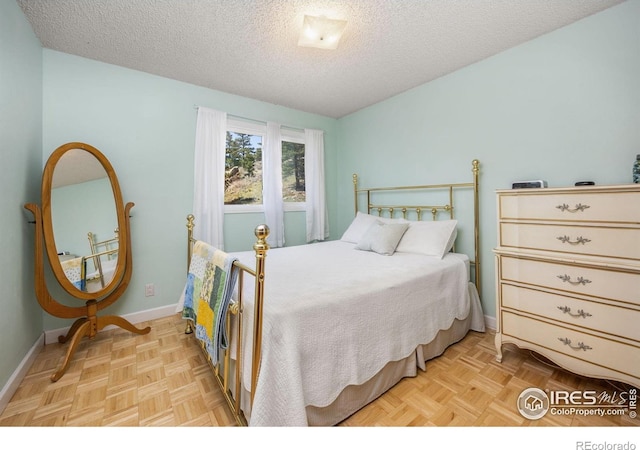 bedroom with a textured ceiling and baseboards