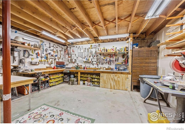miscellaneous room with a workshop area and unfinished concrete floors